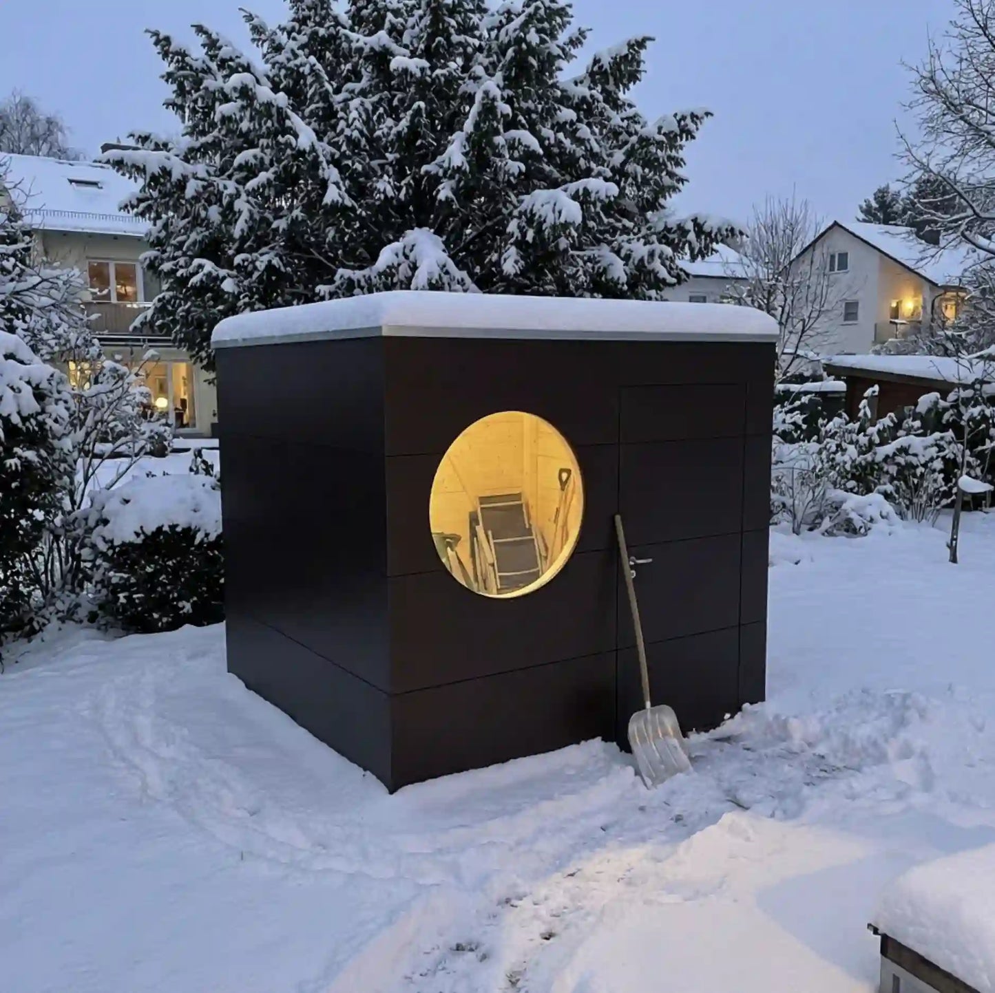 [KI-Bild] Geräte Kubus im verschneiten Garten mit brauner Holzfassade und Rundfenster