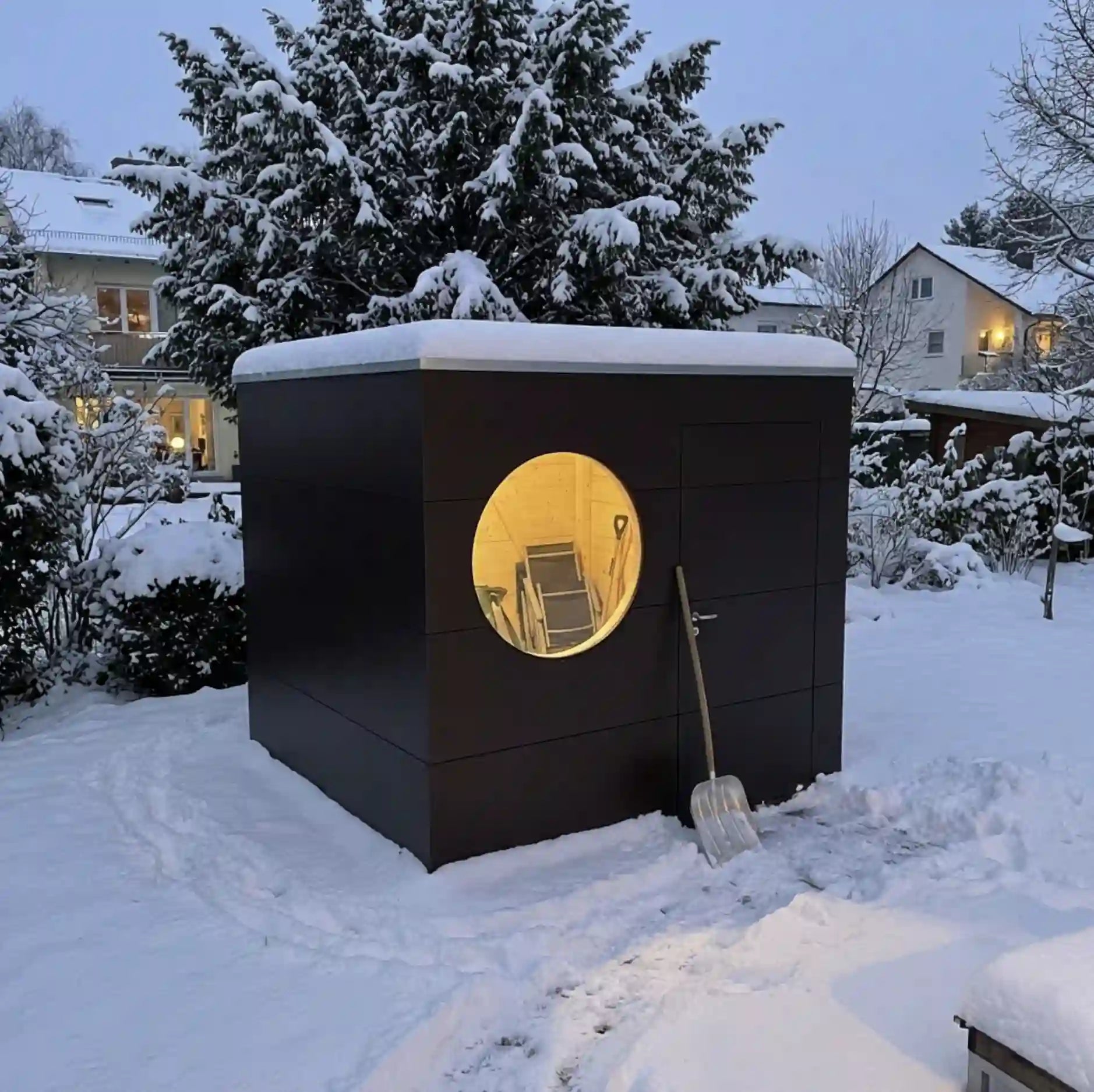 [KI-Bild] Geräte Kubus im verschneiten Garten mit brauner Holzfassade und Rundfenster