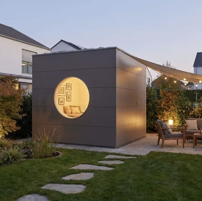 [KI-Bild] Wohn Kubus isoliertes Gartenhaus mit brauner Holzfassade, Rundfenster im abendlichen Garten mit Beleuchtung